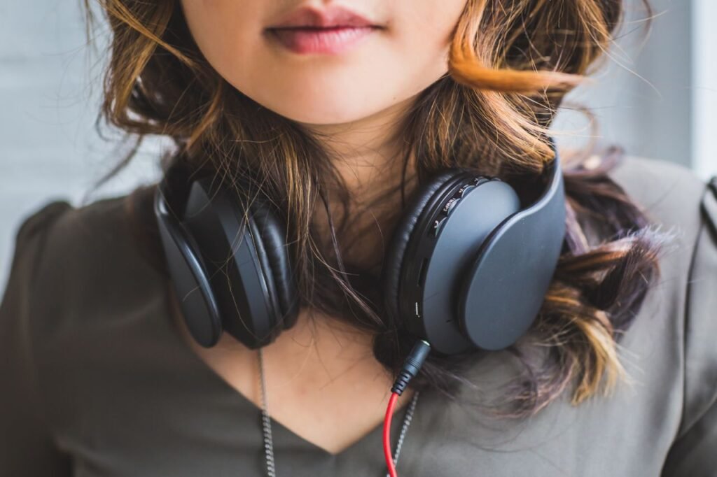 Stylish close-up of a woman with headphones around her neck, showcasing modern music fashion.