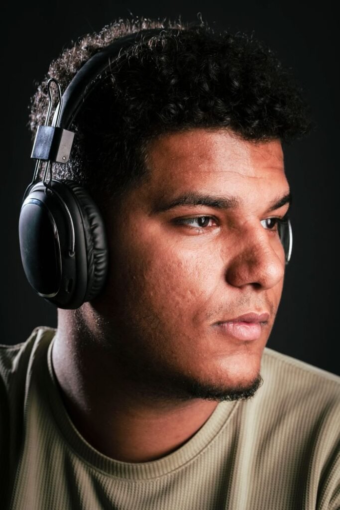 Close-up portrait of a young man wearing headphones, deep in thought.